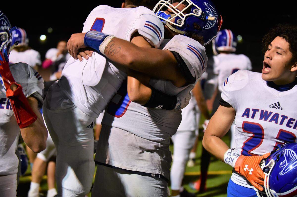 Atwater High senior Xavier Williams (right) gives teammate Angelo Ramirez (3) a bear hug after the Falcons defeated Merced 42-39 in the 50th Santa Fe Bowl on Friday, Oct. 25, 2019 at Veterans Stadium.