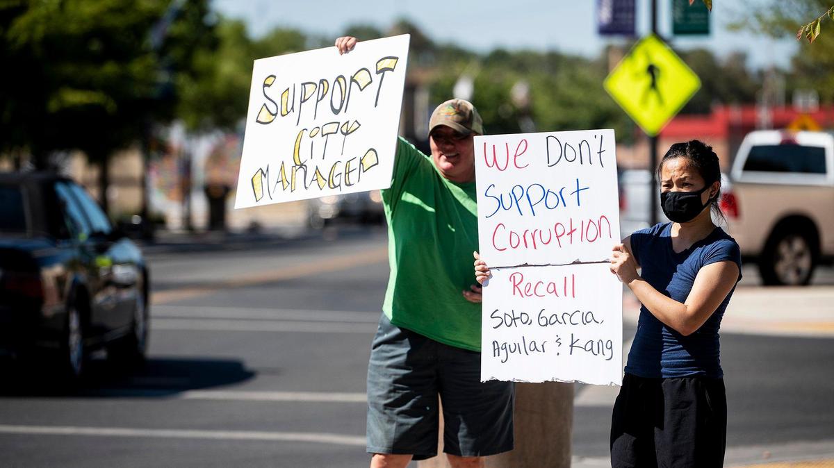 People hold signs during a rally in support of Jose Ramirez outside Livingston City Hall in Livingston, Calif., on Wednesday, July 21, 2021. People gathered to voice their support of Ramirez and question the actions of the Livingston City Council which voted in closed session to terminate his employment as Livingston City Manager.