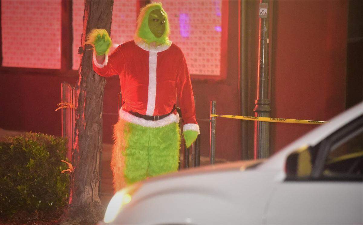 “The Grinch” waves as cars drive by during Merced’s Christmas Tree Lane “reverse parade” on Saturday, Dec. 4, 2021 in Merced, Calif.