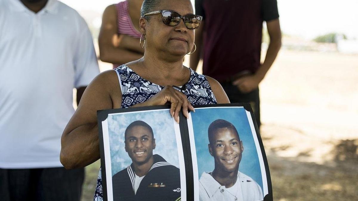 Merced resident Marylene Riley, holds photos of her two sons Michael, left, and Marlis, right, at the cemetery where her two sons are buried in Merced, Calif., on Friday, July 20, 2018. The Merced Police Department announced on Thursday, that an arrest has been made for the 2008 murder of Michael Riley. Riley, a United States Navy veteran who served in Iraq and Afghanistan, was shot and killed on Oct. 7, 2008 near the Village Meadows Apartments in the 1100 block of Loughborough Drive. Nearly a year later, Marlis Riley was killed following a fight with two men on Sept. 12, 2009.