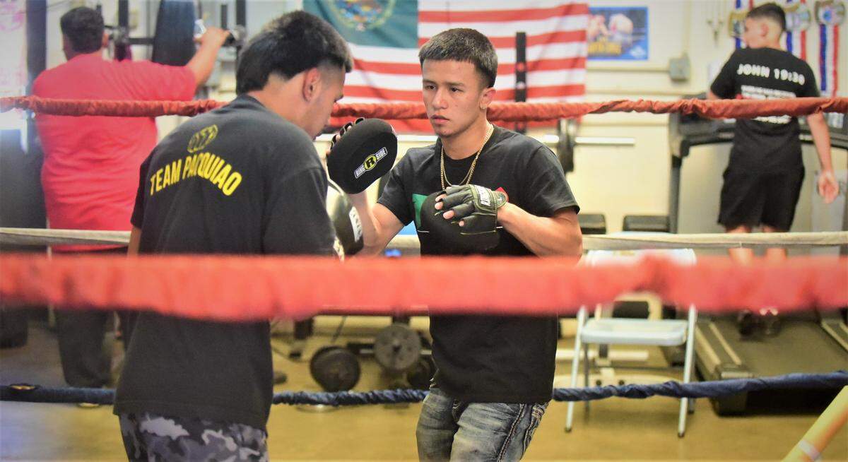 Jesus “Chiquito” Haro (right) trains a fighter during a workout at the Haro Bros Boxing gym in Merced, Calif. on Wednesday, June 15, 2022. Haro, 19, recently won the WBC Straw Weight Youth World Championship in Mexico.