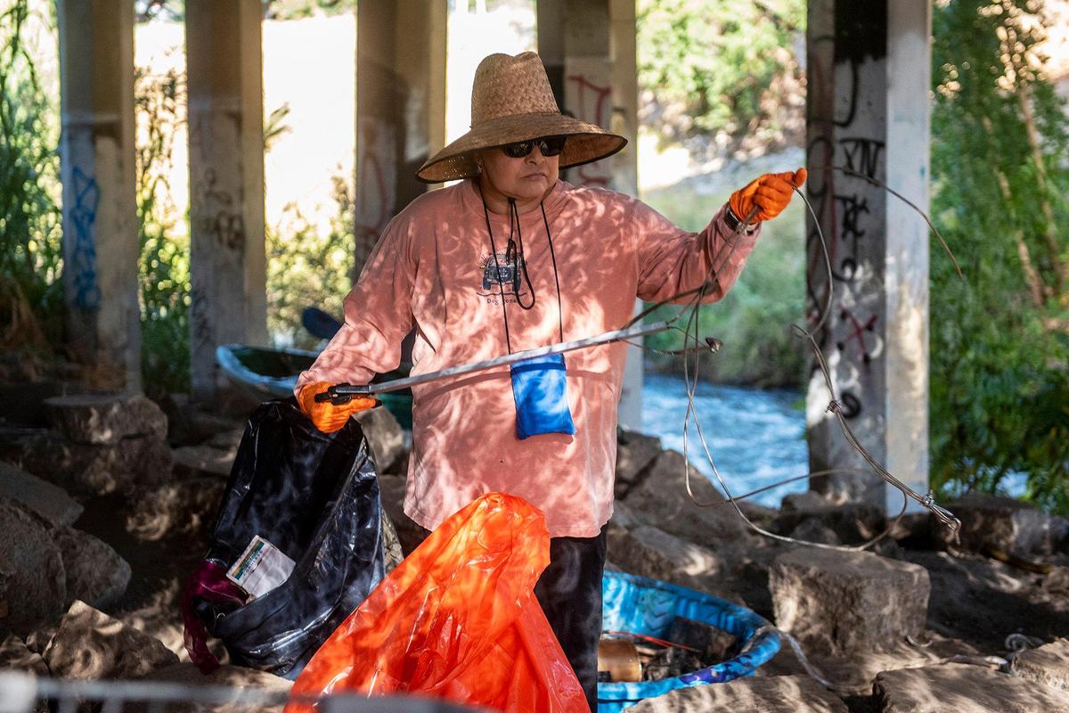 Volunteer Diana Thompson, 59, of Merced, picks up trash and debris along the banks of Bear Creek beneath the McKee Road bridge during a cleanup event presented by the Merced non-profit Bear Creek Yacht Club in Merced, Calif., on Saturday, Oct. 14, 2023.