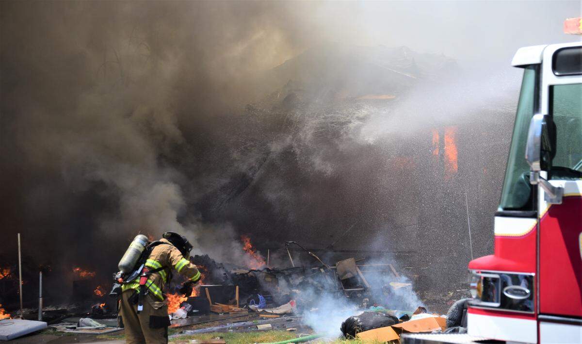 Firefighters battle a fire that damaged two homes in Merced, Calif. on Friday, July 28, 2023.