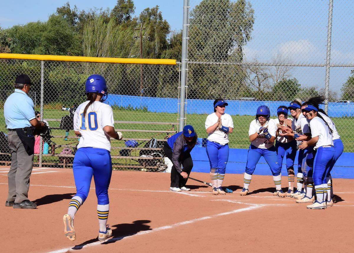 Dos Palos High senior Janessa Jasso is greeted at home by her teammates after hitting a solo home run in the Broncos’ 11-0 win over Mendota on Tuesday, April 9, 2019 at Dos Palos High in Dos Palos, Calif.