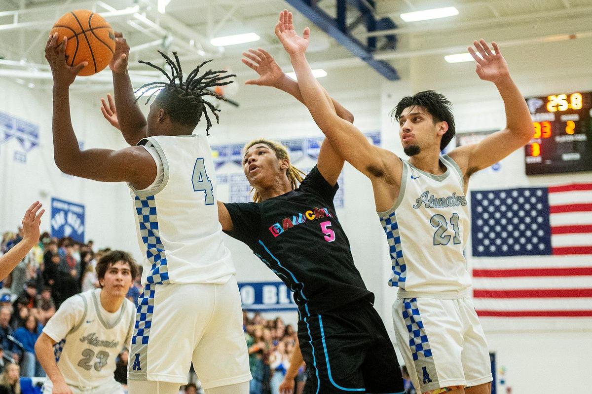 Atwater sophomore Ali Banks Jr. (4) and senior Fernando Torres Diaz (21) fight for possession of the ball with El Capitan sophomore Anthony Jones (5) during a game at Atwater High School in Atwater, Calif., on Wednesday, Jan 17, 2024.
