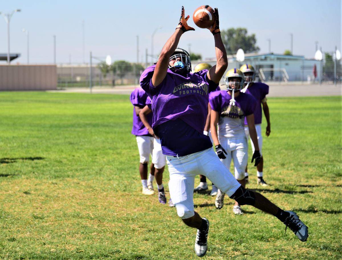Livingston High School senior Max Nolasco pulls down an interception during practice on Tuesday, Aug. 1, 2023.