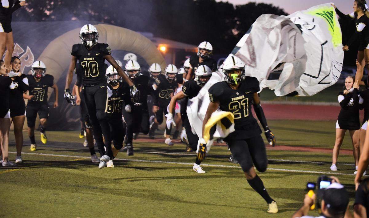 Trey Paster (21) leads Buhach Colony onto the field on Friday, Aug. 30 against Tracy at Dave Hone Stadium in Atwater, Calif.