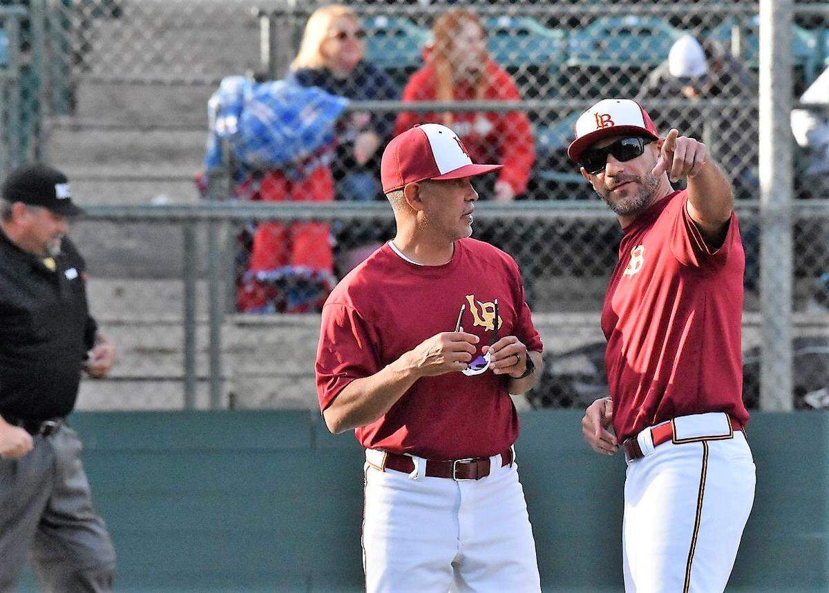 Los Banos High baseball coach Pat Fuentes talks with assistant coach David Zuniga before a playoff game at Tony Zupo Field earlier this season in Lodi, Calif.