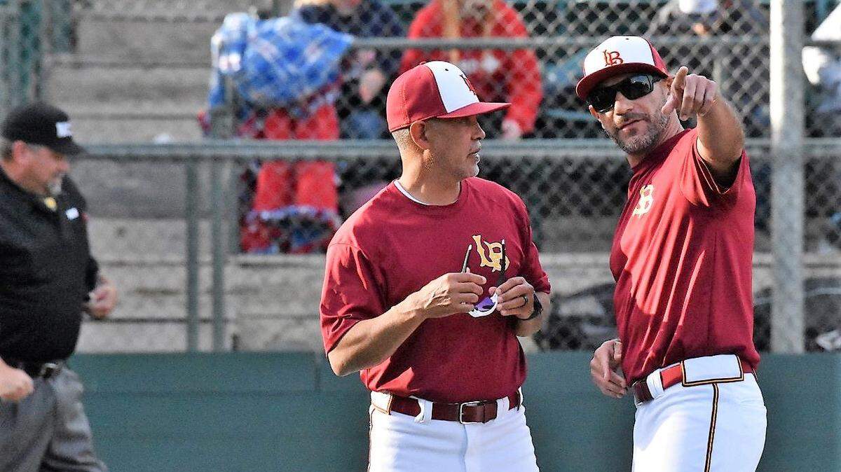 Los Banos High baseball coach Pat Fuentes talks with assistant coach David Zuniga before a playoff game at Tony Zupo Field earlier this season in Lodi, Calif.
