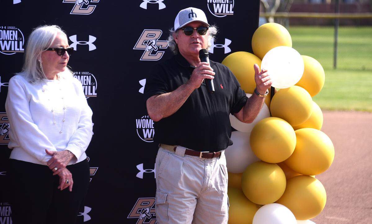 Former Buhach Colony High softball coach Bobby Dallas (right) speaks during a pregame ceremony in which the school named the softball field Bob E. Dallas Field in honor of his late father on Friday, March 22, 2024.