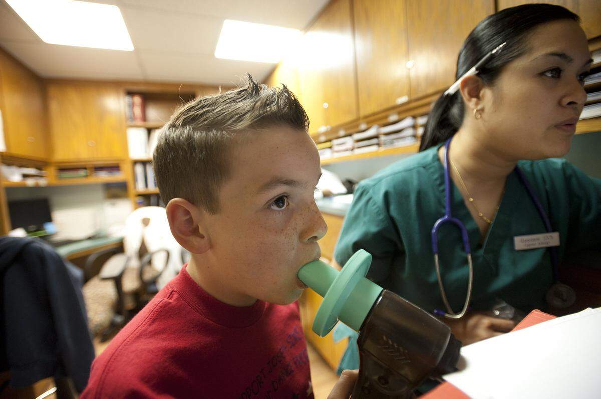 Queenie Evangelista, a licensed vocational nurse at Capital Allergy and Respiratory Disease Center in Sacramento, measures Adam Fruda’s breathing during a inhalation and exhalation exam in May 2011.