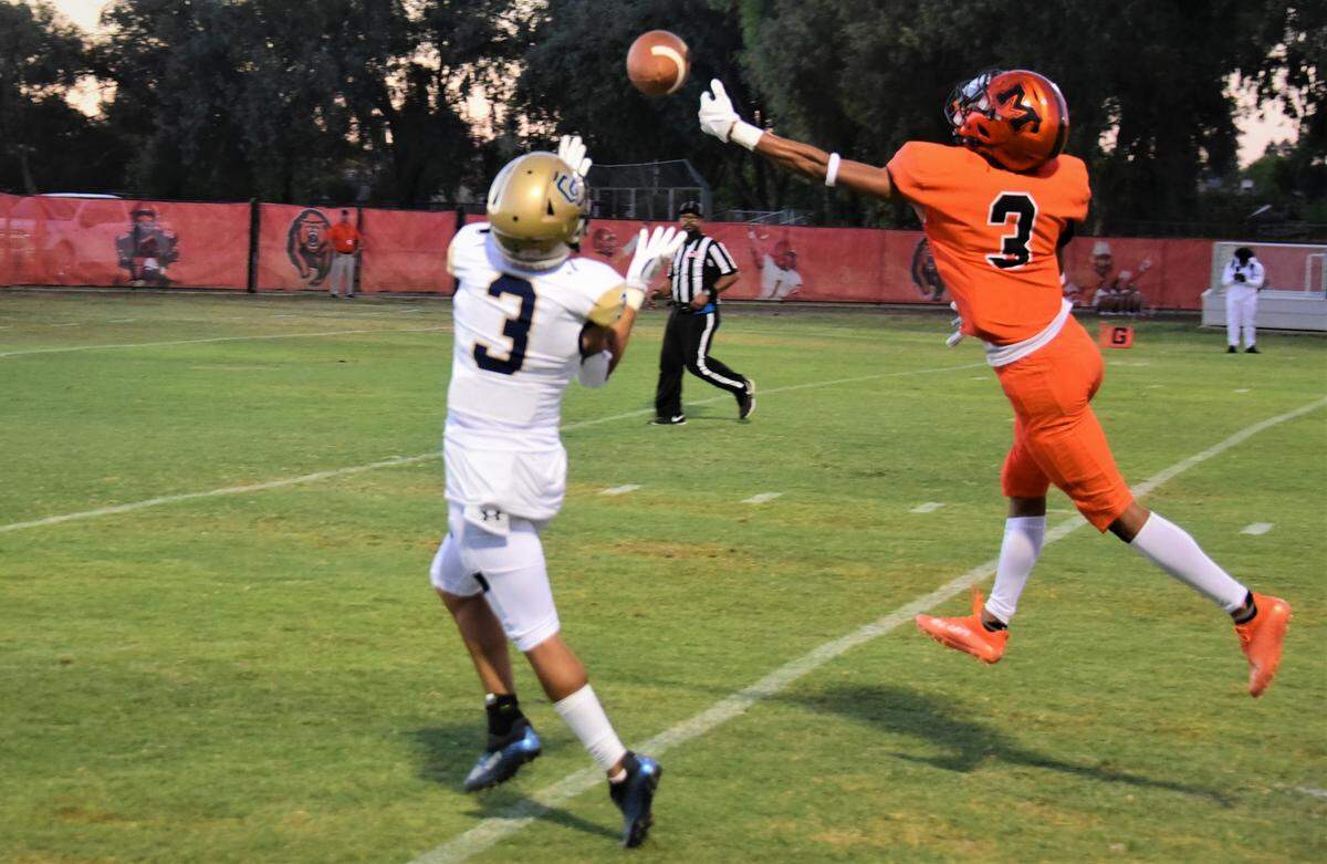 Merced High School senior defensive back Cristian Castro (3) tips a pass away from Central Catholic receiver Trace Hernandez during a game on Friday, Aug. 19, 2022 at Cathie Hostetler Stadium.