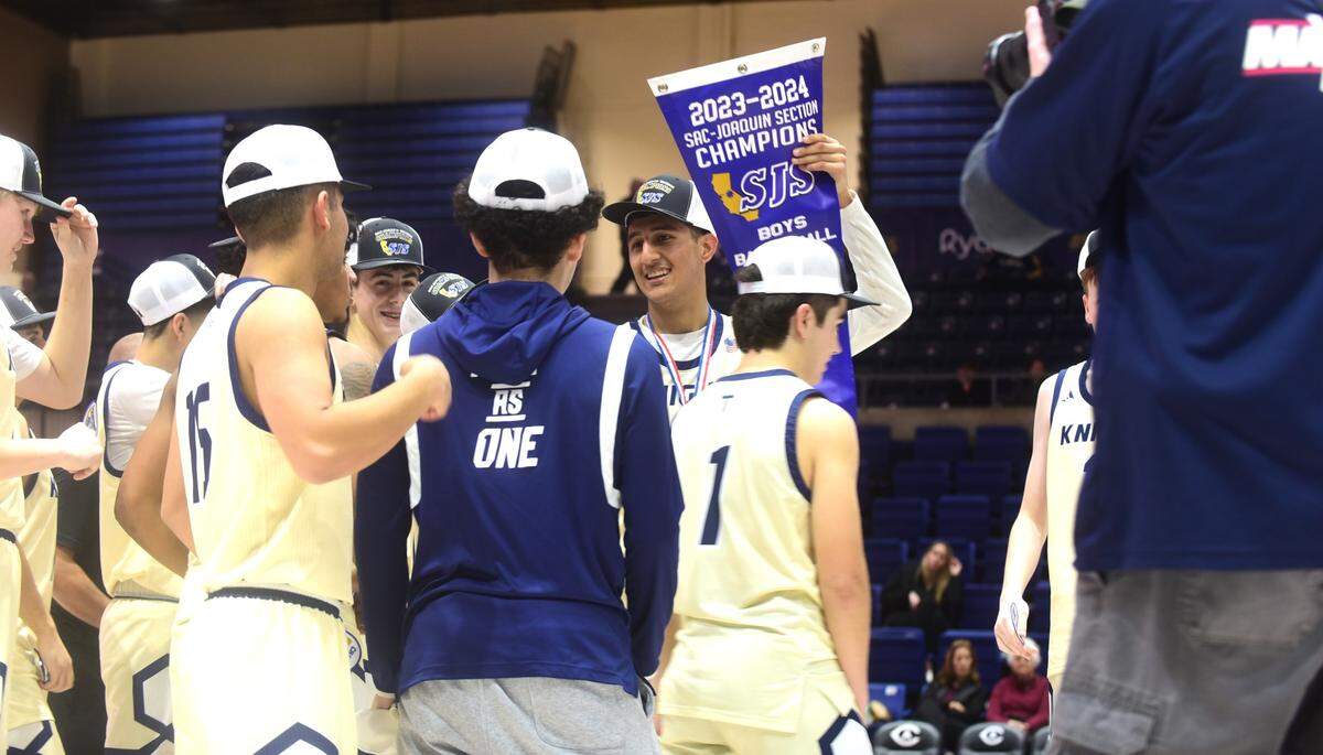 Stone Ridge Christian High senior Brock Richards holds up the blue section championship banner after the Knights defeated Valley Christian 91-77 to win the Sac-Joaquin Section Division VI championship at UC Davis on Friday, Feb. 23, 2024.