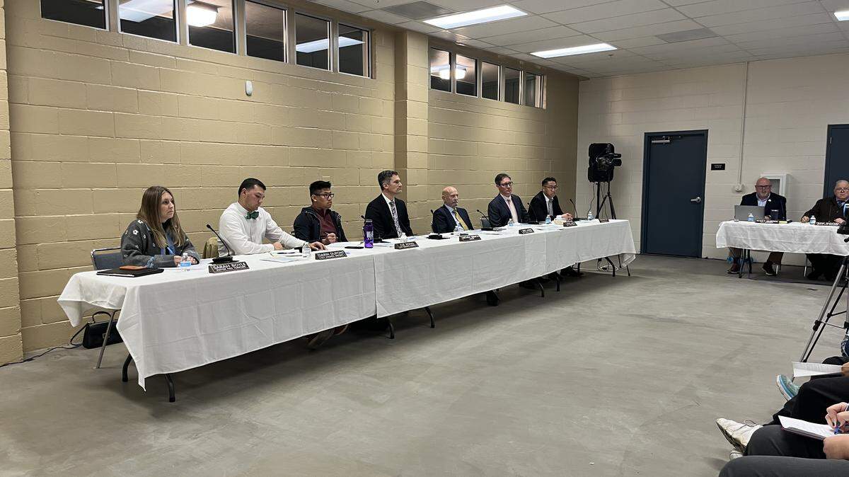 Members of the Merced City Council sit at a long table covered with a white tablecloth and name plaques.