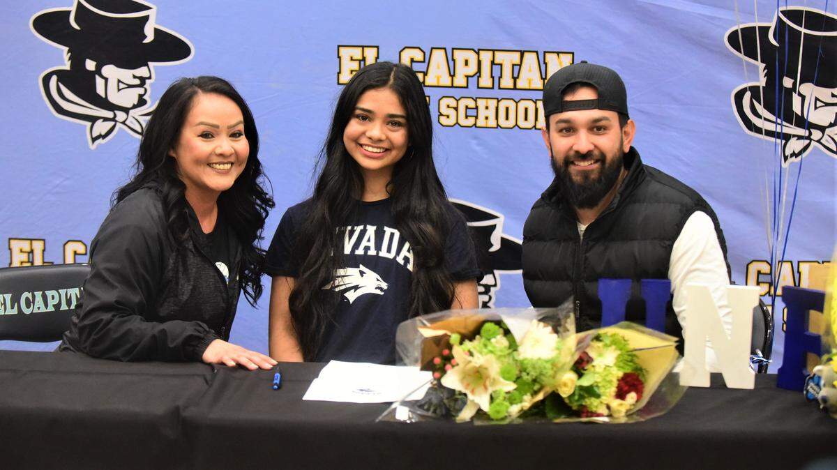 El Capitan High School senior Leah Mendoza (center) poses for photos with Gaucho coaches Chela Moreno and Brandon Sanchez after signing her national letter of intent to play volleyball at the University of Nevada-Reno on Thursday at El Capitan High School in Merced, Calif.