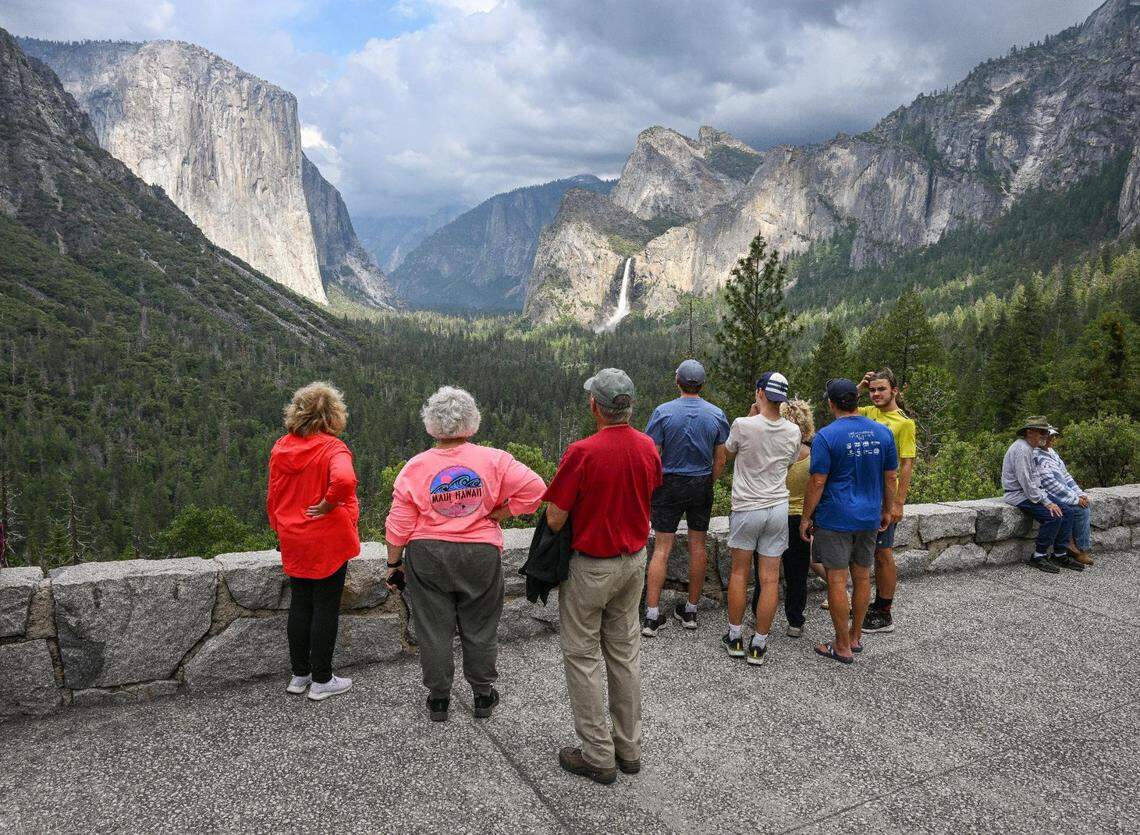 Yosemite National Park visitors take a look at El Capitan rock formation, left, and Bridalveil Fall from Tunnel View in Yosemite Valley in 2023.