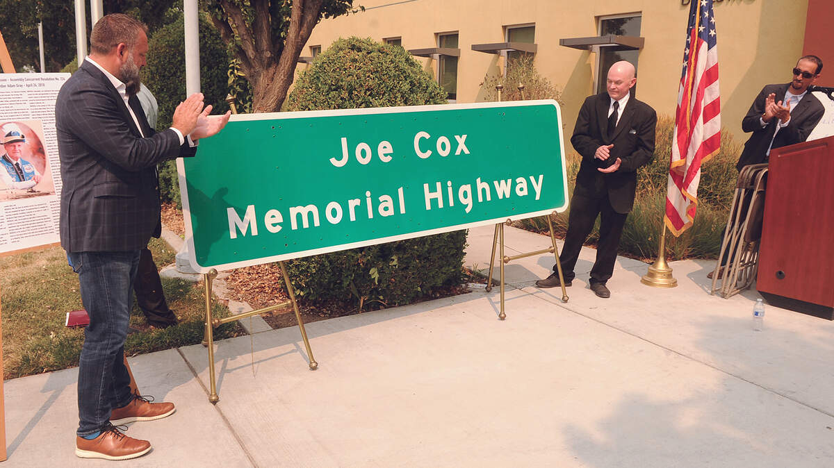 California State Assembly Member, Adam Gray, left, and Joel Cox clap as the Joe Cox Memorial Highway sign is unveiled Sat., Aug. 7, 2021 at Merced College Los Banos Campus.