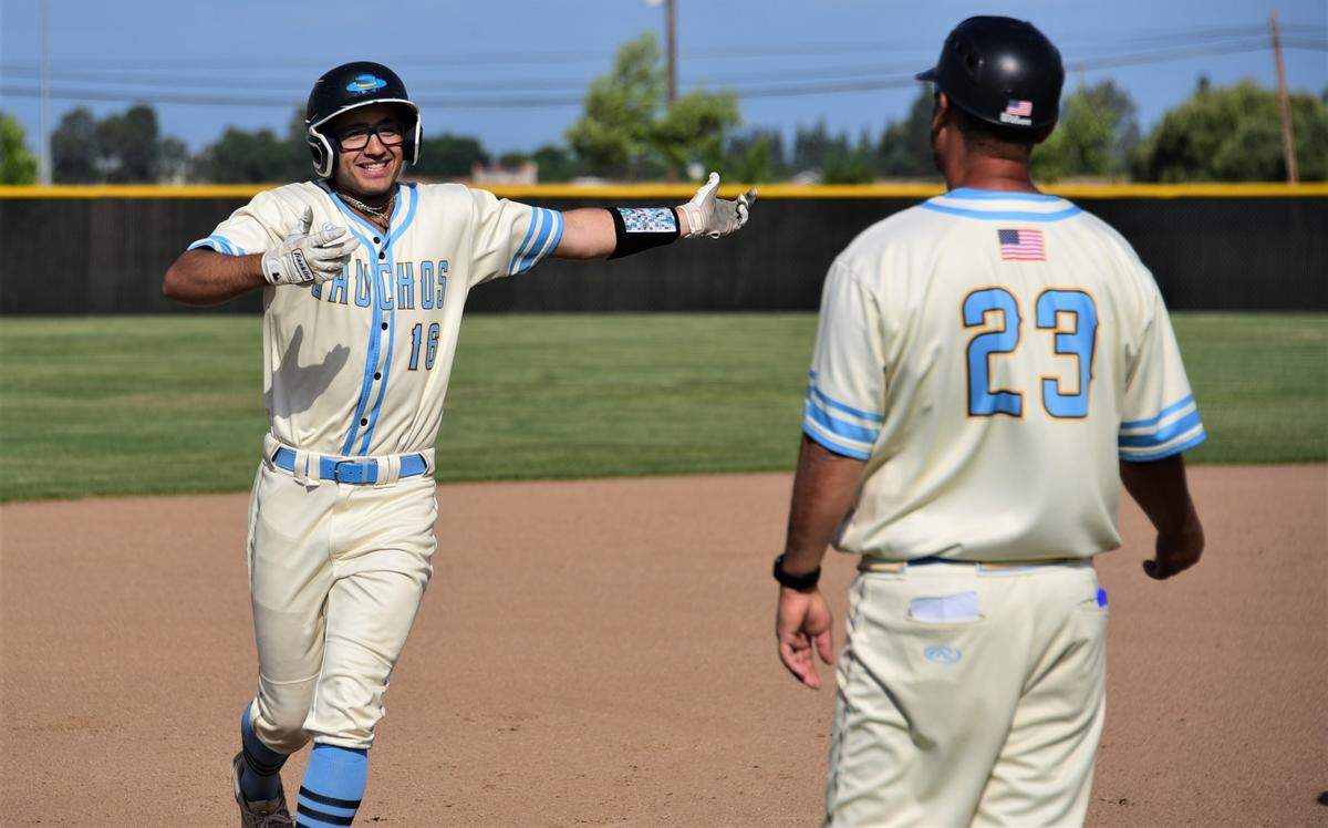 El Capitan High School junior Juan Munoz (16) smiles as he rounds third base in front of Gauchos coach Aaron Ruiz after Munoz hit a two-run homer during a playoff game against Bear Creek on Tuesday, May 9, 2023 at El Capitan High School.