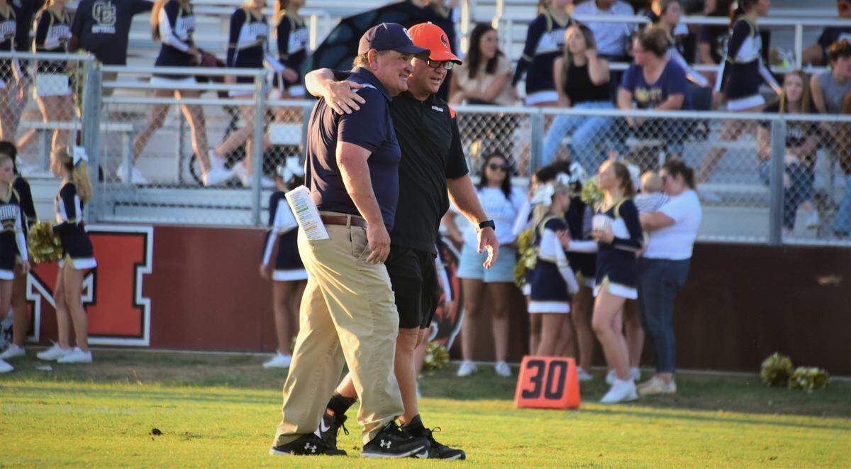 Central Catholic head coach Roger Canepa greets Merced head coach Rob Scheidt before the two teams played on Friday, Aug. 19, 2022 at Merced High’s Cathie Hostetler Stadium.
