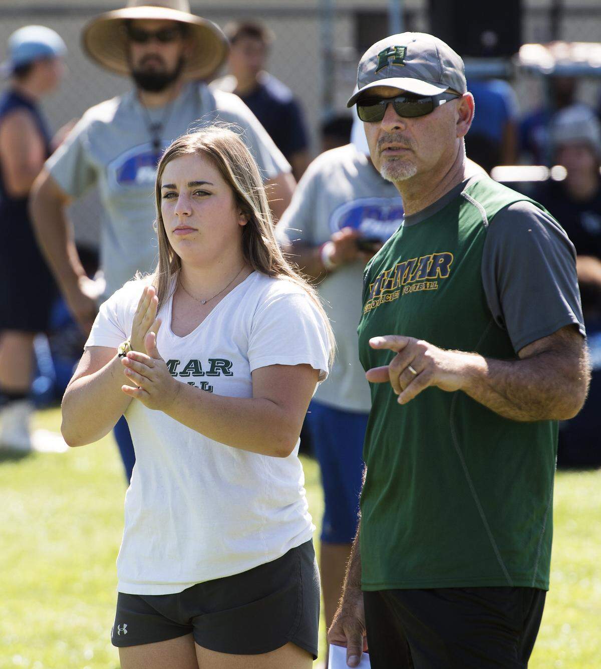 Junior Morgan Amarante signals the offensive plays for Hilmar coach Frank Marques, right, during the 11th annual MJC Passing Tournament at Modesto Junior College. Marques has led the Yellowjackets to eight section title game appearances in his 16 seasons as the Hilmar head coach.