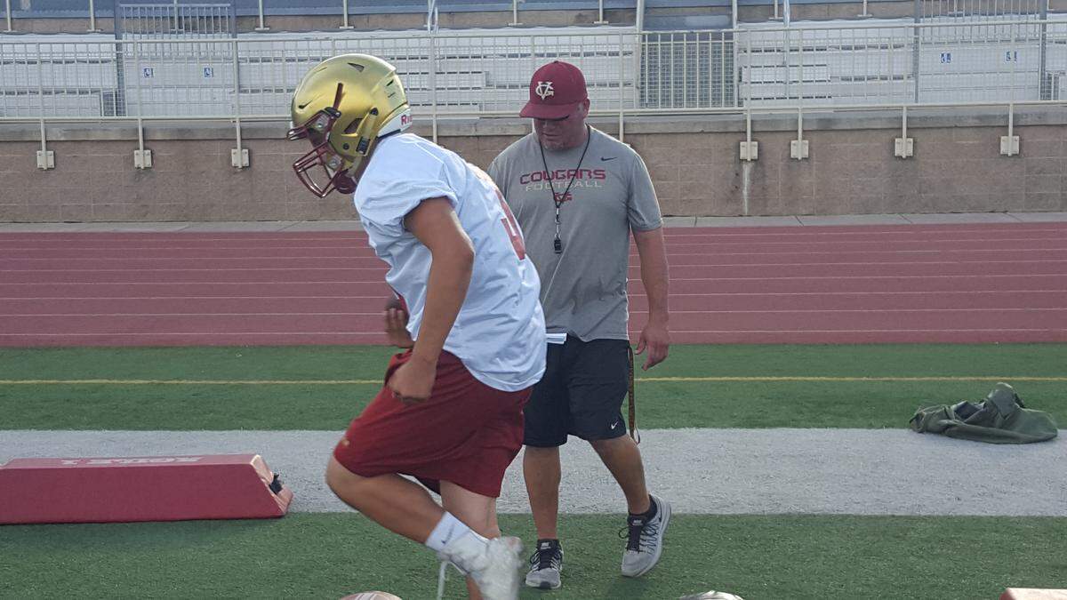 Golden Valley head coach Rick Martinez looks on while senior Eric Diaz runs through a drill during the Cougars first official football practice on Monday, July 23, 2018 at Veterans Stadium. Shawn Jansen/Merced Sun-Star.