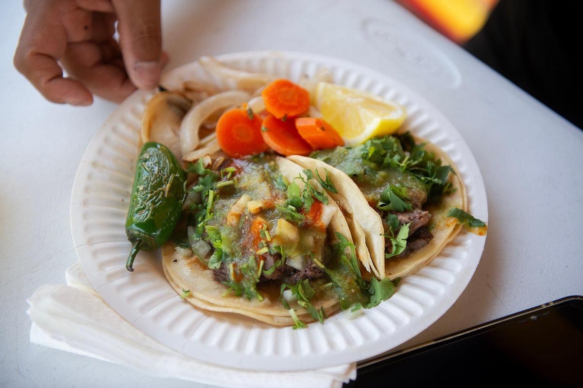 Taquizas Gracian customer Evh, 45, of Merced, sits down to enjoy an order of tacos in Merced, Calif., on Tuesday, June 10, 2025.