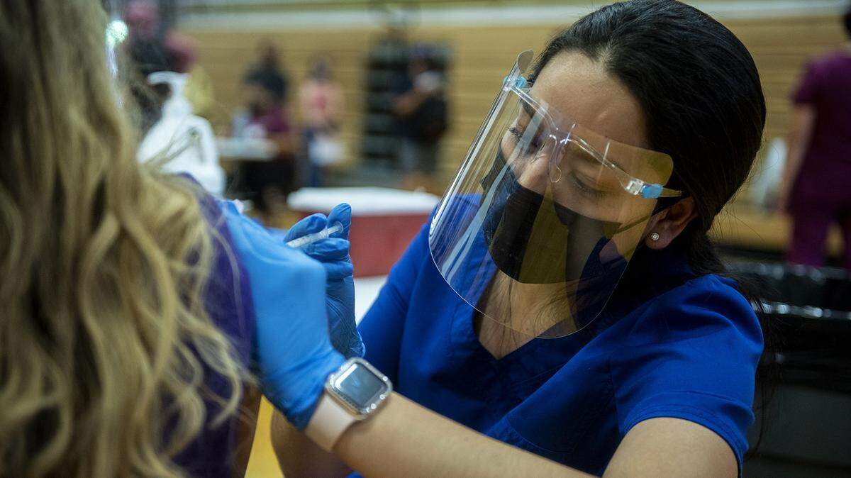 Registered Nurse Myrna Pulido administers the Pfizer COVID-19 vaccine to a student during a vaccination clinic held by the Merced Union High School District in partnership with Castle Family Health Centers, for children 12 years of age and older at Livingston High School in Livingston, Calif., on Thursday, May 13, 2021.