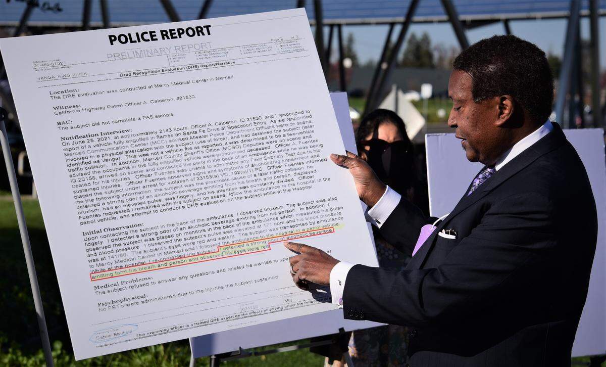 Attorney John Burris holds up a copy of the police report as he alleges his client King Vanga, 20, was falsely accused of a DUI and mistreated by Atwater police and California Highway Patrol when he was arrested on June 25 for allegedly causing the Atwater-area crash that killed husband and wife Jose Juarez and Pamela Juarez.