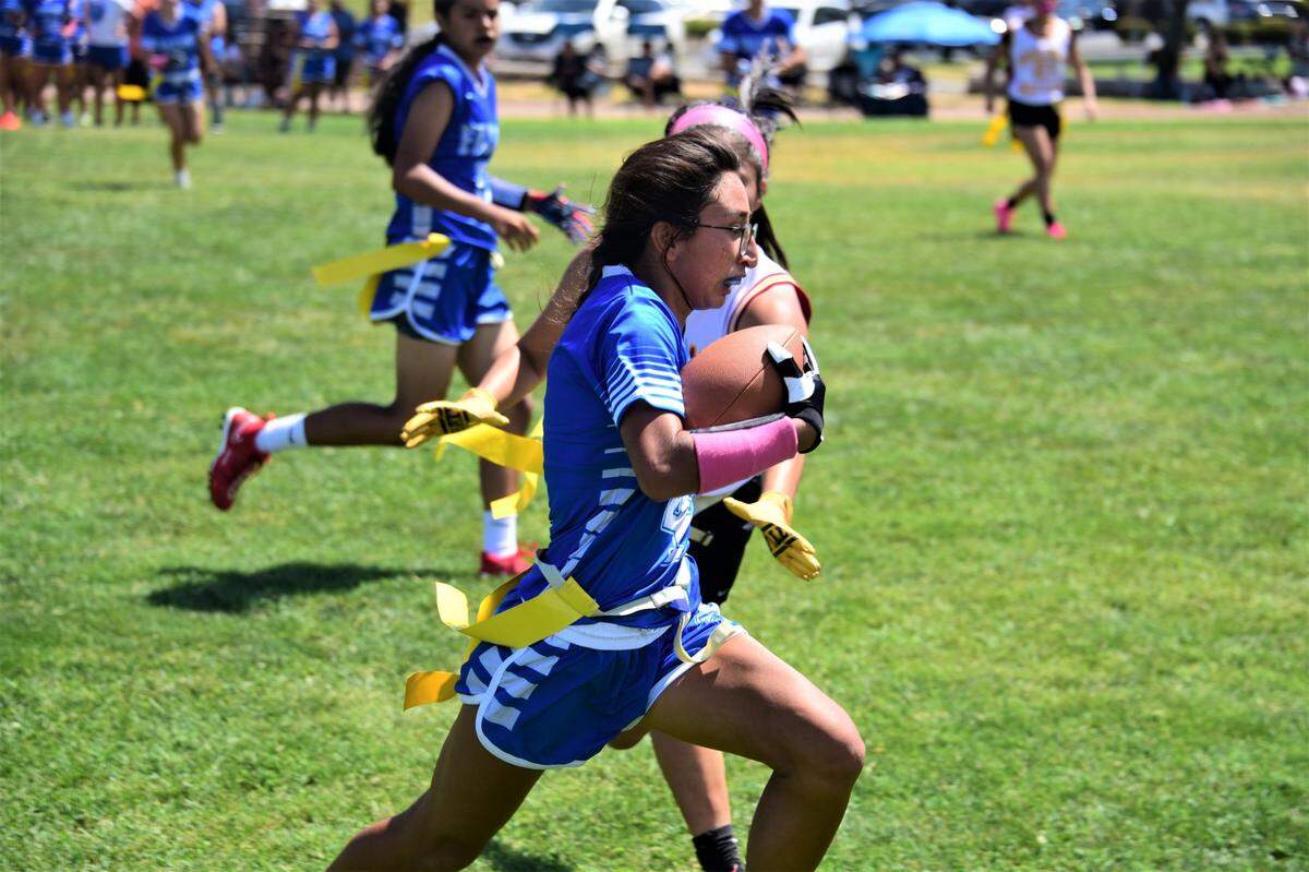 Atwater High School senior Nayeli Garcia runs will the ball during a flag football game against Golden Valley on Saturday, Aug. 19, 2023 at Merced High School in Merced, Calif.