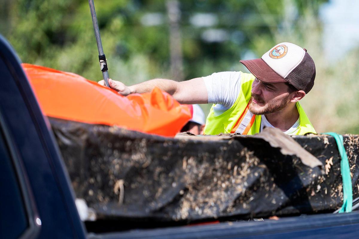 Merced resident Zachary Wells, 35, co-founder and president of the Merced non-profit Bear Creek Yacht Club, places trash collected from the banks of Bear Creek into the bed of a pickup truck during a cleanup event near McKee Road and East South Bear Creek Drive in Merced, Calif., on Saturday, Oct. 14, 2023.