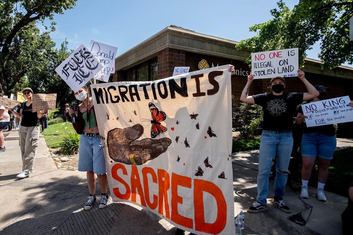 Protesters hold signs as they take part in a “No Kings” protest in Merced, Calif., on Saturday, June 14, 2025.