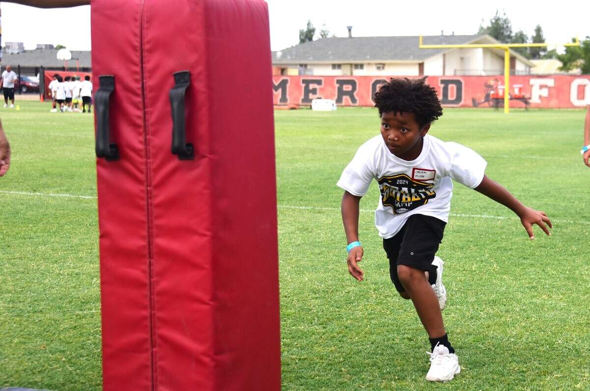 Josiah Miller, 10, practices his tackling during a drill at the David Perales Football Camp held at Merced High School on Saturday, July 13, 2024 in Merced, Calif.