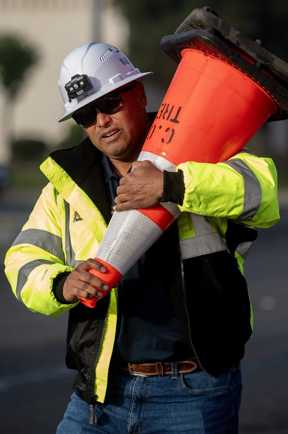 City of Merced Arborist and Public Works Director for Parks and Trees Division, Angel Nunez, 46, removes cones from the roadway as crews work to remove selected trees from the median along West Olive Avenue in Merced, Calif., on Thursday, Nov. 6, 2025. 