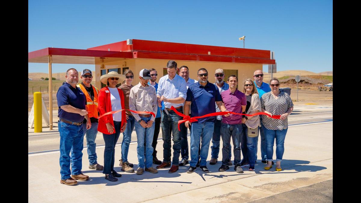 Merced Mayor and Merced County Association of Governments Board Chair Matt Serratto, center, cuts a ribbon in front of a new scale house with members of the MCAG Board of Directors and Regional Waste Management Authority staff during a ceremony unveiling recently completed improvement projects at the Billy Wright landfill in Merced County, Calif., on Friday, May 19, 2023.