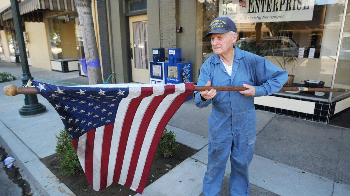 GENE LIEB/LOS BANOS ENTERPRISE Joe Cox is shown here, putting American Flags throughout the City of Los Banos