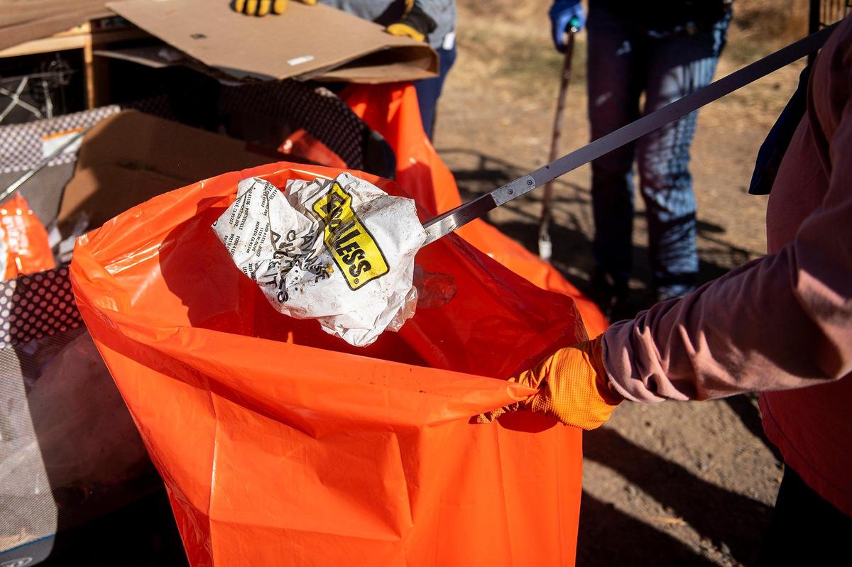 Trash and other debris collected from the banks of Bear Creek is placed into bags during a cleanup event presented by the Merced non-profit Bear Creek Yacht Club in Merced, Calif., on Saturday, Oct. 14, 2023.