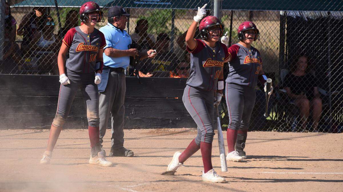 Golden Valley”s Maddy Stokes (16) and Bree Barner (18) celebrate after scoring runs on a two-run single by KD Felix during a 6-0 win against Merced on Wednesday, May 5, 2021.