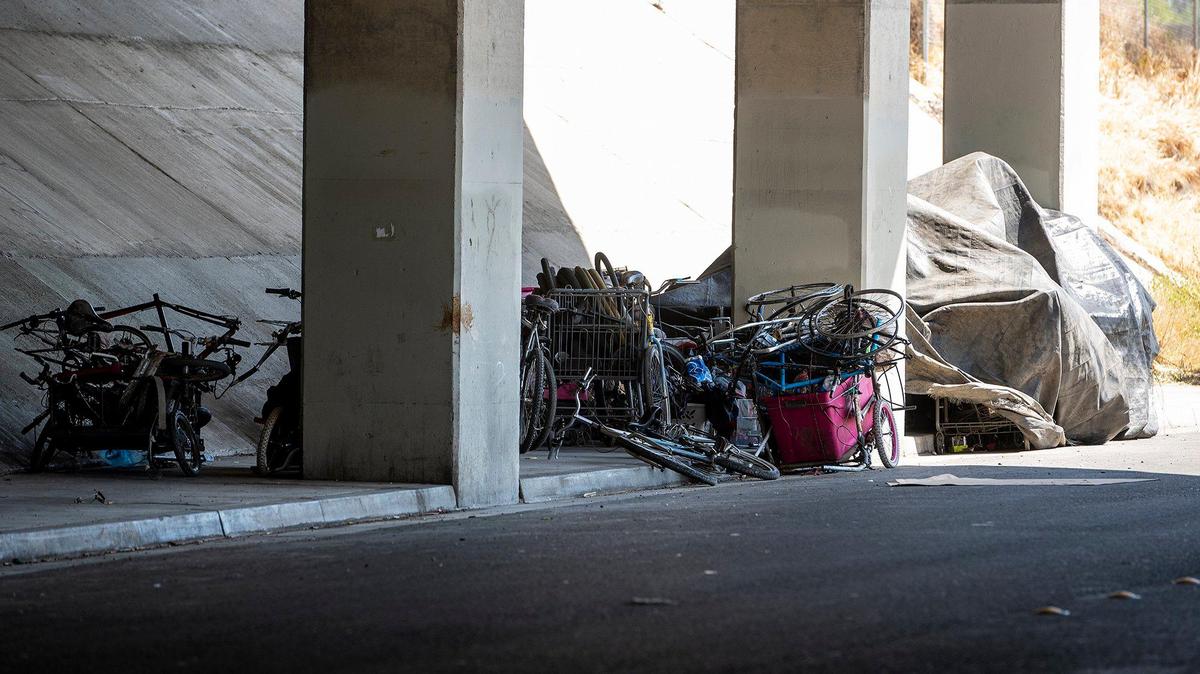 Various items and a makeshift shelter located along 15th Street under the Highway 99 overpass in Merced, Calif., on Tuesday, April 12, 2022.