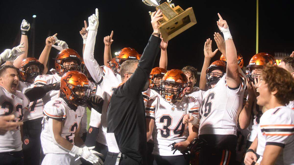 Merced High football coach Rob Scheidt holds up the Mayor’s Cup as the Bears celebrate a 33-7 win over Golden Valley on Friday, April 9, 2021 at Veteran Stadium.