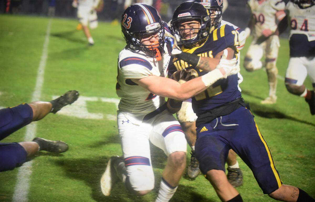 Merced College receiver Dasani Tate (22) is tackled by College of Sequoias defender Brendan Freeney (23) during the Valley Center Bowl game on Thursday, Dec. 2, 2021 at Merced College.