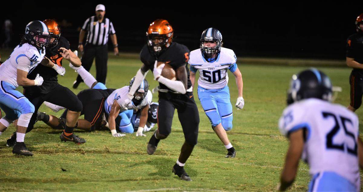 Merced High School junior running back Chase Smith runs the ball against Downey during a game on Friday, Sept. 2, 2022 at Cathie Hostetler Stadium.