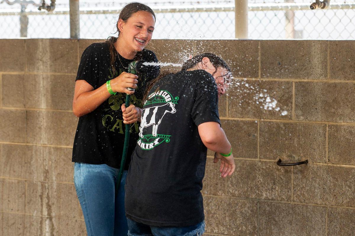 McSwain 4H member Faith, left, sprays El Nido 4H member Gianna, right, while engaging in a friendly water fight with others at the Merced County Fair in Merced, Calif., on Thursday, June 6, 2024.