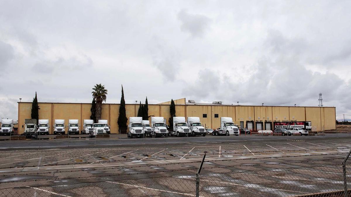 Trucks and trailers sit outside the now closed Yosemite Wholesale Distribution Center located at 2674 Vassar Ave. in Merced, Calif., on Tuesday, Nov. 26, 2024. The Save Mart Companies announced the planned closure of the facility in September.