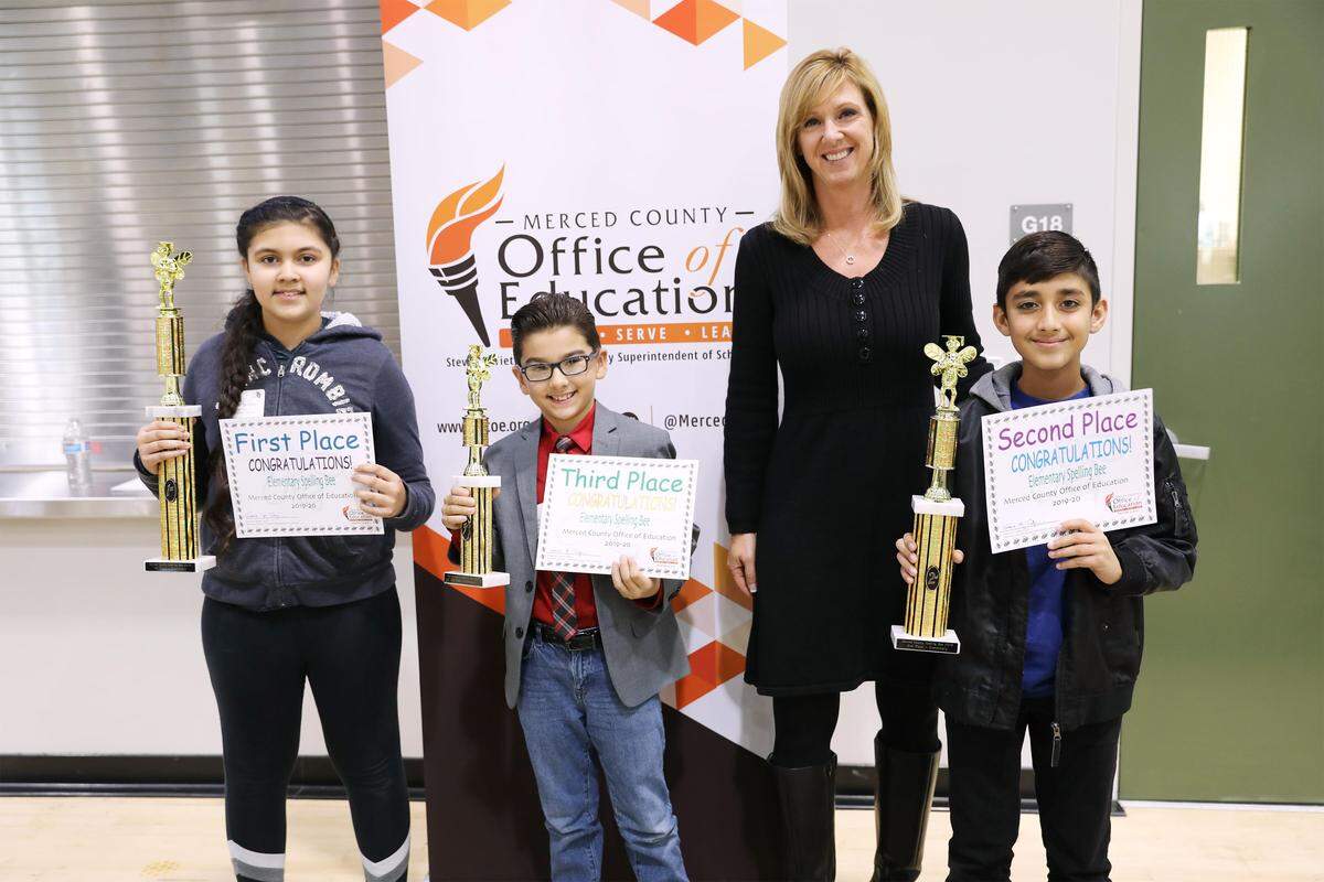 Michelle Symes, Director of District Support Services at the Merced County Office of Education, the wordmaster for the Merced County Elementary Spelling Bee, poses with the top three winners, from left: first place winner Harneet Sandhu, a fifth grader at Westside Elementary School in Los Banos; third place winner Steven Wade, a fourth grader at Bellevue Elementary School in Atwater; and second place winner Arvin Judge, a sixth grader at R.M. Miano Elementary School in Los Banos.