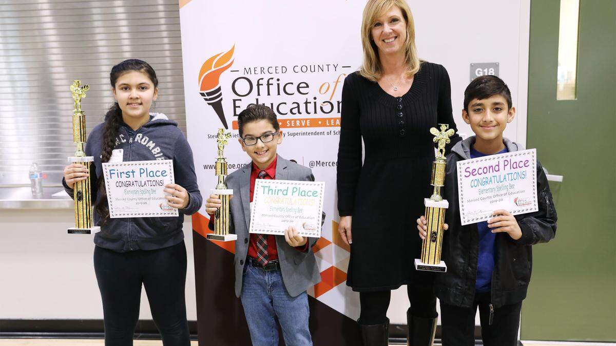 Michelle Symes, Director of District Support Services at the Merced County Office of Education, the wordmaster for the Merced County Elementary Spelling Bee, poses with the top three winners in 2019, from left: first place winner Harneet Sandhu, a fifth grader at Westside Elementary School in Los Banos; third place winner Steven Wade, a fourth grader at Bellevue Elementary School in Atwater; and second place winner Arvin Judge, a sixth grader at R.M. Miano Elementary School in Los Banos.