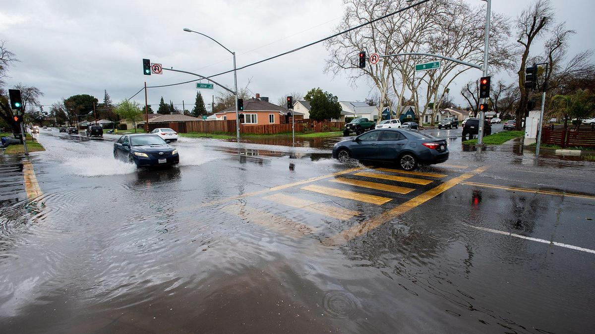 Motorists navigate a flooded section of R Street at the intersection with West 22nd Street in Merced, Calif., on Tuesday, March 14, 2023.