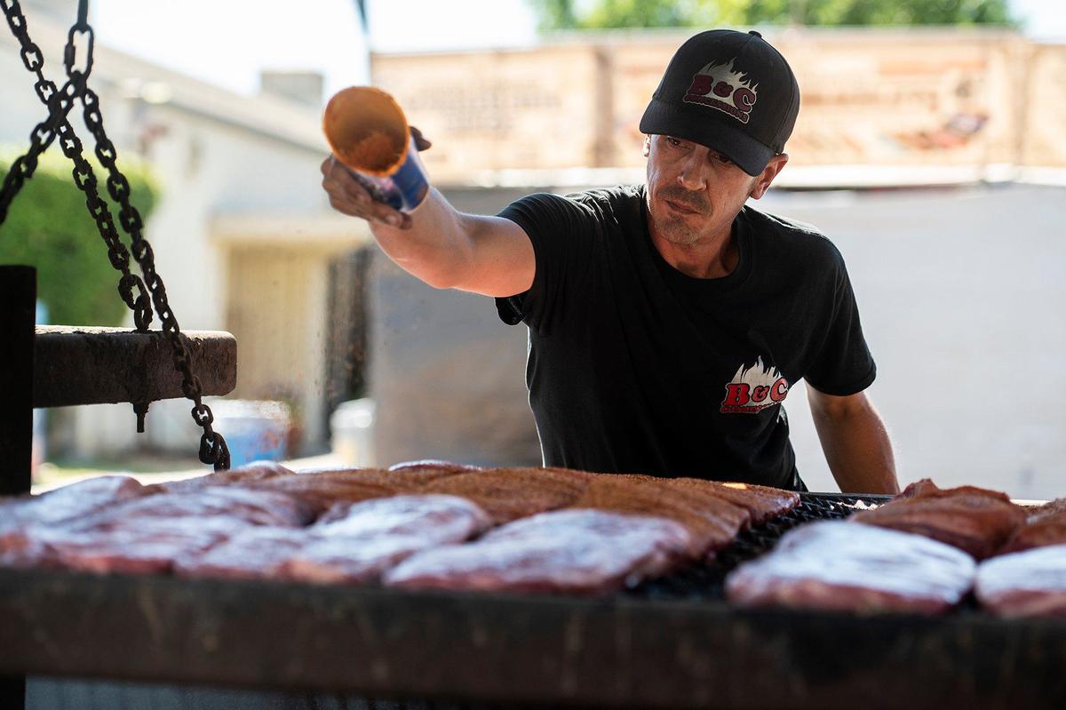 Anthony Rita, 40, of Madera, adds seasoning to ribs and tri-tip at the All American BBQ food stand at the Merced County Fair in Merced, Calif., on Thursday, June 6, 2024.