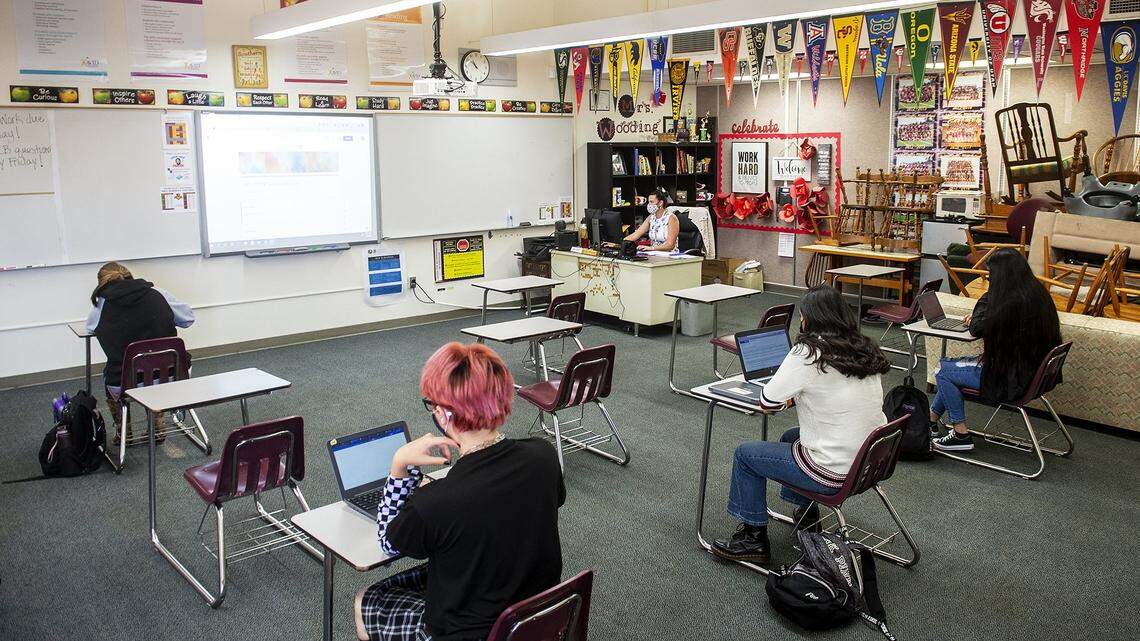 Students wear masks and socially distance as teacher Jacqueline Wooding, instructs students both in class and online during an AP Language and Composition class at Golden Valley High School in Merced, Calif., on Monday, Nov. 2, 2020. The Merced Union High School District welcomed students back Monday with an A/B schedule with half of the student body alternating days they will be at the school, according to the district.
