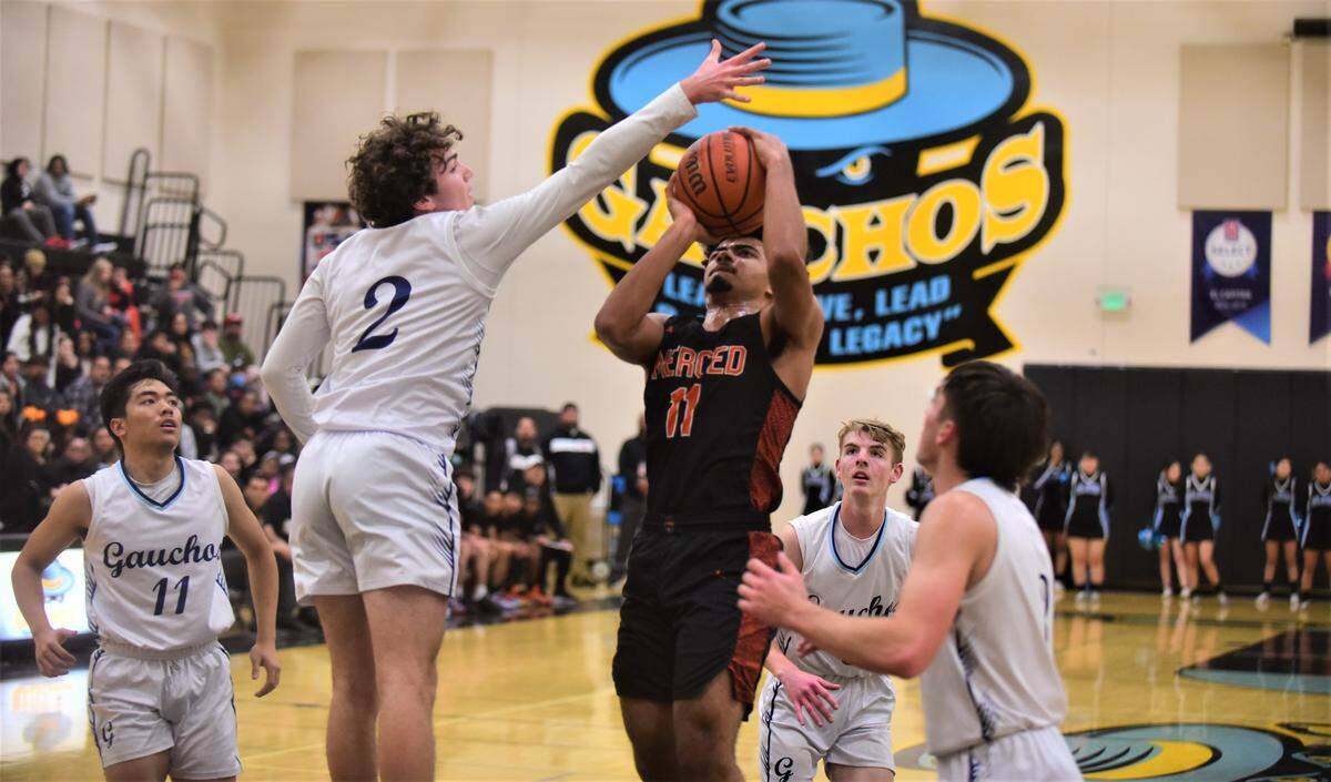 El Capitan High senior Will Bain (2) goes up to block a shot by Merced High senior John Simpson (11) during a game on Wednesday, Jan. 4, 2022 at El Capitan High School.