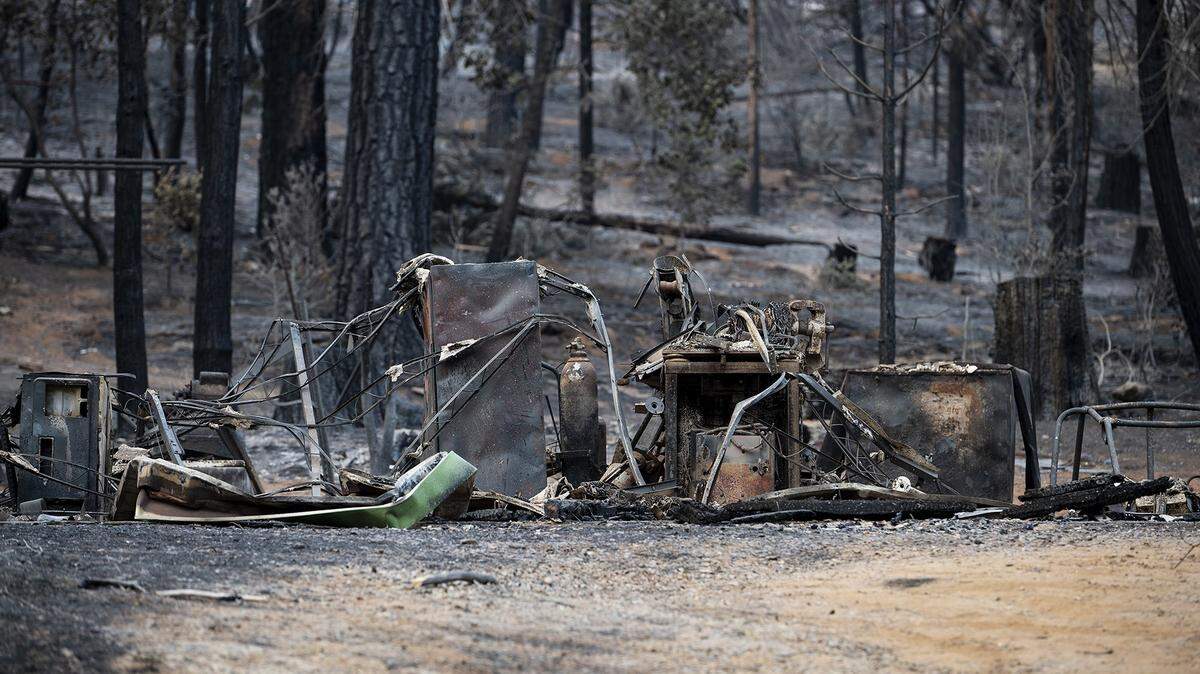 Charred items on a property along Jerseydale Road as firefighters continue to battle the Oak Fire in Mariposa County, Calif., on Tuesday, July 26, 2022.